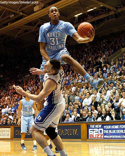 John Henson skies over Miles Plumlee, avoids charge, draws foul, and makes acrobatic basket.